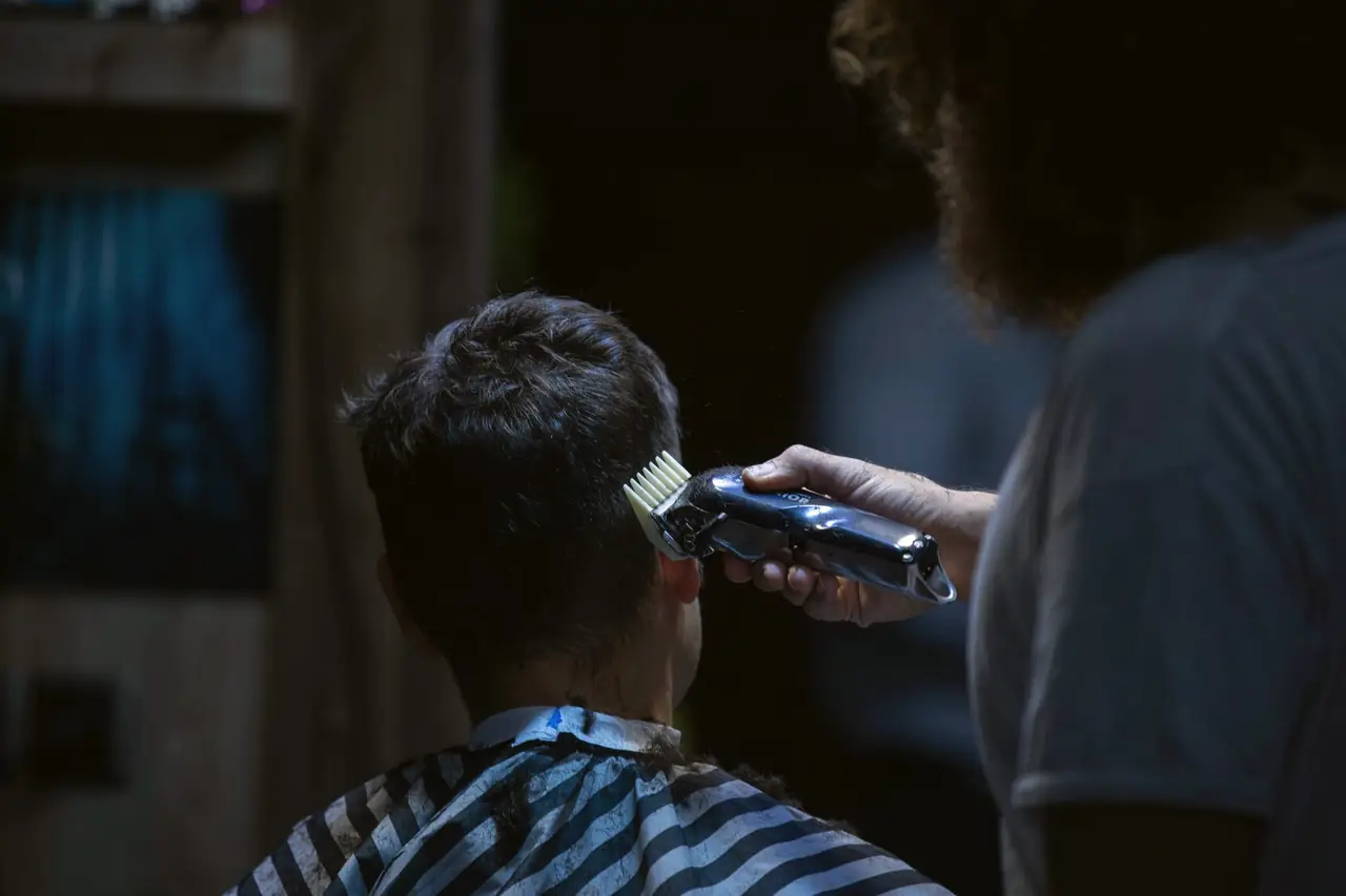 A barber running clippers along a client’s neckline