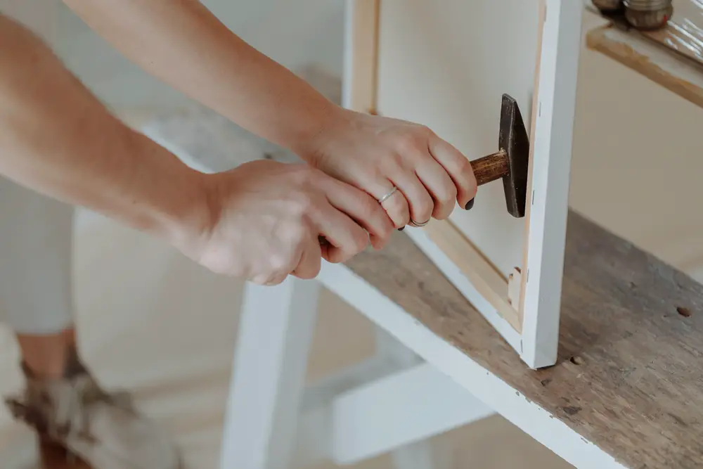 Hands assembling a wooden frame on a workbench